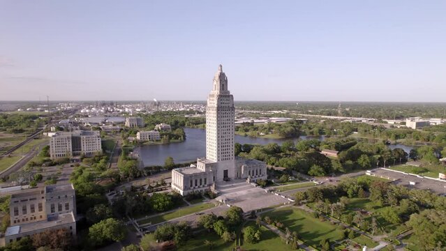Aerial Panning Shot Of State Capitol Building Against Clear Sky In City, Drone Flying Over Green Landscape -  Baton Rouge, Louisiana