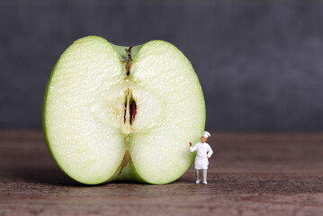 A cut apple and miniature people. Business concept with half an apple and miniature people.
