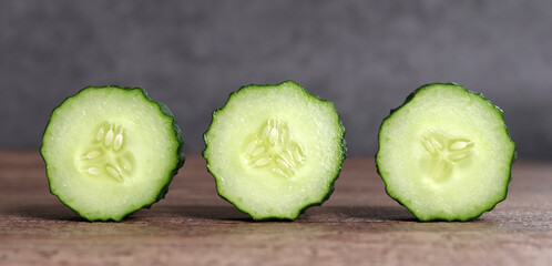 A close-up image of three slices of cucumber that is freshly cut.
