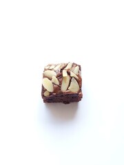 baked brownies with pieces Almonds peanut on top on a white background
