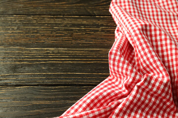 Red and white checkered tablecloth on wooden background