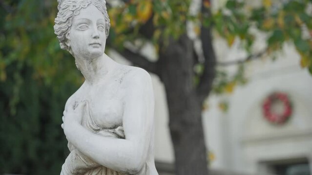 Timeless statue of a half naked woman in the garden 