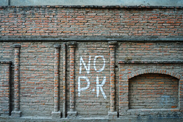 'No parking' Hand writing sign on red brick wall