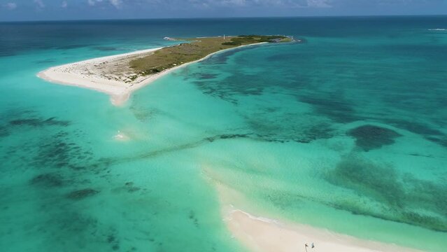 Aerial approach on caribbean island Cayo de Agua without peculiar isthmus, long and narrow strip of land joins island