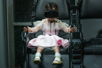 A young girl with a virtual reality headset enjoys a virtual environment. A girl in a virtual helmet. The concept of modern virtual reality technologies in the field of entertainment.