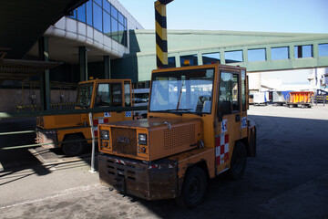 evocative image of engines for moving planes parked in an airport
