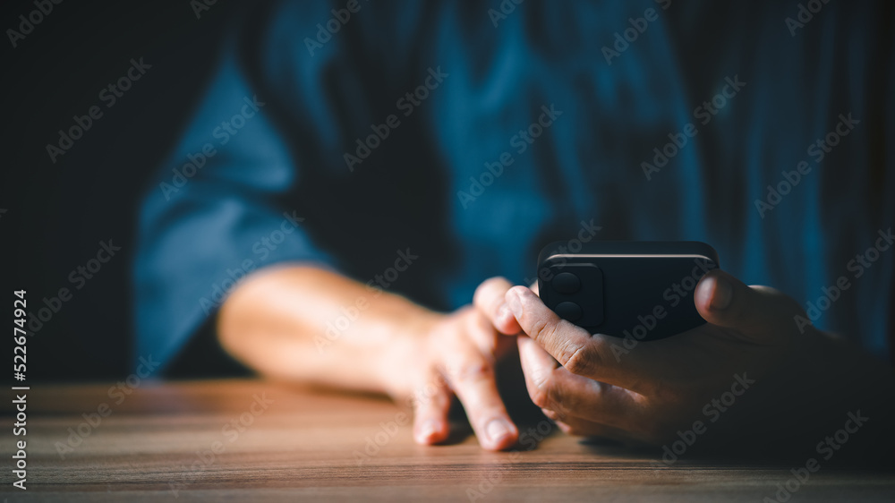 Poster Closeup image of a man holding and using mobile phone or smartphone.