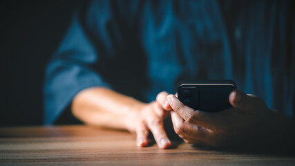 Closeup image of a man holding and using mobile phone or smartphone.