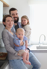 Young family with daughter and son in the kitchen