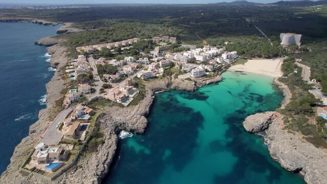 Aerial drone shot of the shore of Cala Millor, Mallorca, Balears Islands, Spain. the town of Cala Millor and the mountains in distance at dusk. 4K videos