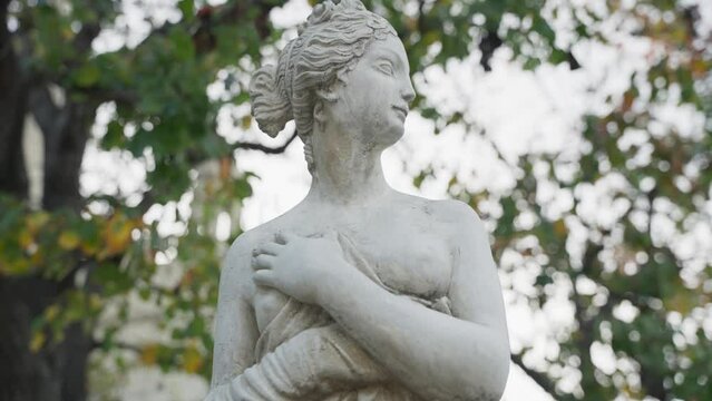 Statue of a woman half naked in a garden