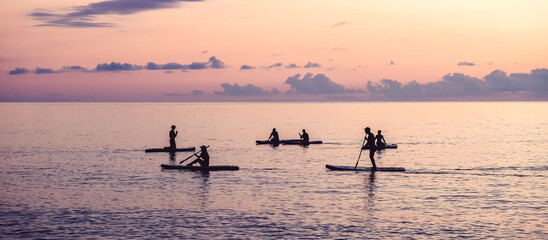 Travel.Silhouette man sea sup at sunset.outdoor travel.paddle standing, silhouette  man  beach  sunset. eco travel, taking care  your physical and mental health. Leisurely life and relaxation at sea.