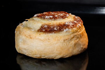 Cinnamon bun baking and rising on tray in electric oven - close up view. Swedish cuisine, homemade bakery, food, cooking and pastry concept