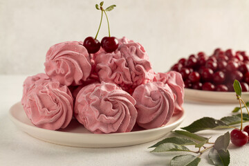 Tasty sweet zephyr and cherries on light background