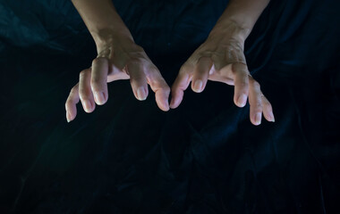 Hand and finger gestures show magic on black background with light and shadow. Look mysterious and...