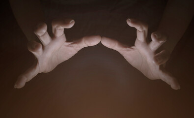 Hand and finger gestures show magic on black background with light and shadow. Look mysterious and...
