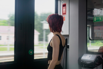 young woman is preparing to get off at a station from a suburban train car