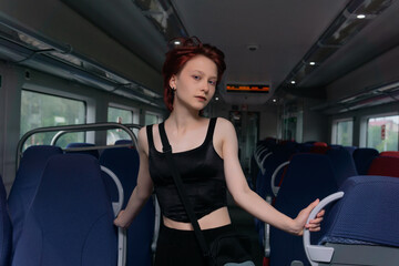 beautiful young red-haired woman posing in a commuter train car
