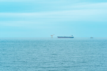 foggy seascape with a tanker near an oil terminal located far out to sea, top view