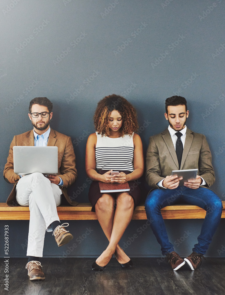 Poster group of design interns on wireless online devices waiting at a job interview of a startup company. 