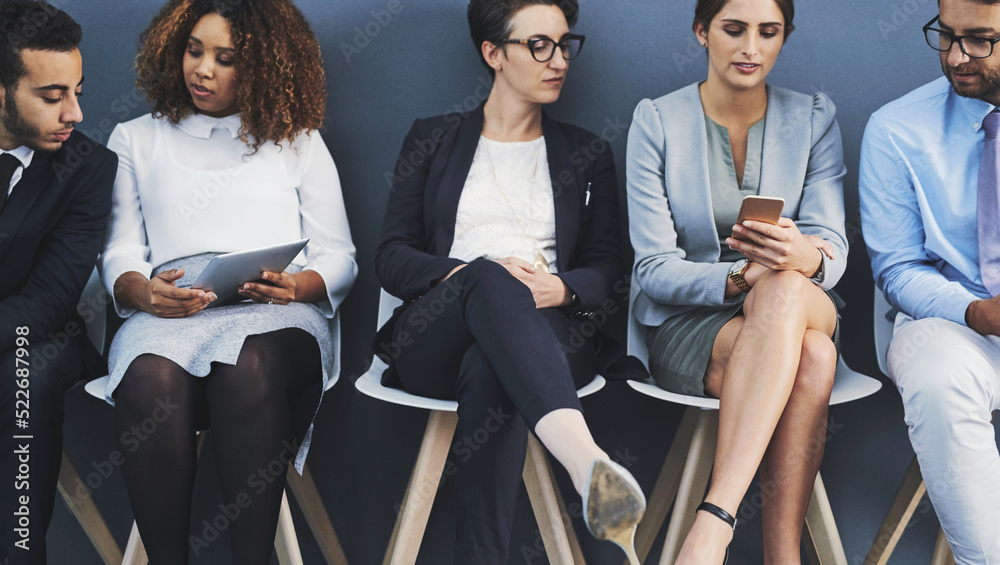 Aufkleber Business people waiting in line and sharing information with technology. Professionals sitting in a row for an interview against a grey background. A digital marketing team collaborate and network