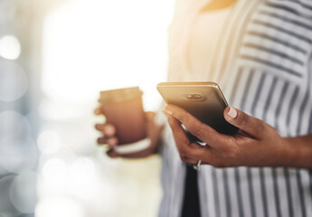 Closeup of a casual business woman using a phone for communicating with clients while working remotely from home with flare. Professional black female employee holding her work and personal cellphone