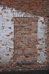 Red brick wall with bricked up doorway