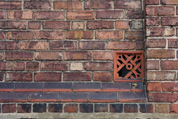 Red brick wall with ventilation brick