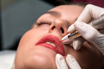 Permanent make up procedure. Lip makeup in tattoo salon. - obrazy, fototapety, plakaty