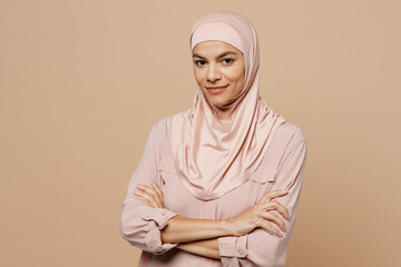 Young smiling arabian asian muslim woman she wear abaya hijab pink clothes hold hands crossed...