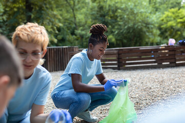 Group of volunteers cleaning up forest from waste, community service concept