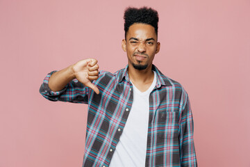 Young sad upset man of African American ethnicity 20s he wearing blue shirt showing thumb down...