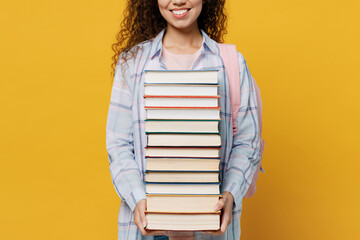 Cropped young smiling happy fun smart black teen girl student she wear casual clothes backpack bag hold pile of books isolated on plain yellow color background. High school university college concept.