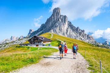 Poster de jardin Dolomites Group of hikers walks towards mountains