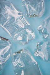 Empty rumpled used plastic bottle on blue background. Top view, copy space. Pollution, environmental protection concept. Reuse garbage, recycle, plastic free. Earth, world water day