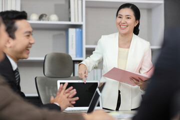 Collaborative process of professional businesspeople going over on new project together, using computer presentation and brainstorming ideas, coworker and working together at office meeting concept