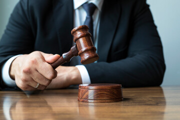 Judge with gavel at wooden table indoors, closeup. Criminal law