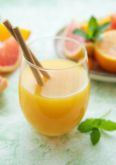 Glass of juice and citrus fruits