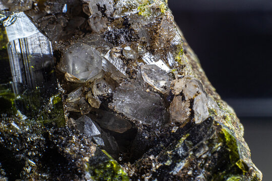 Ultra macro picture of small quartz points with one dark green epidote spike on matrix