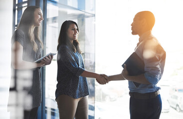 Handshake greeting between business women, entrepreneur and accountant banker with tablet and portfolio. Happy female and male corporate professionals meeting, welcoming or making deal on investment - obrazy, fototapety, plakaty
