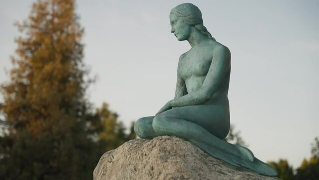 Statue of a naked woman sitting on a rock 