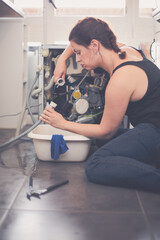 Woman try to fix the leak of her washing machine