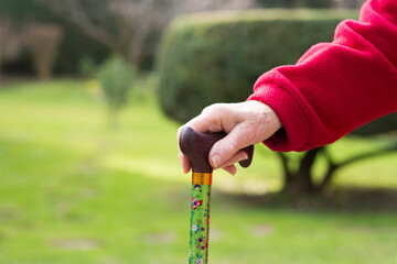 hand of ederly woman holding a cane at her retirement home