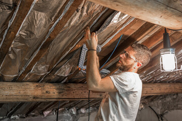 Worker with glasses and protective mask isolating the ceiling