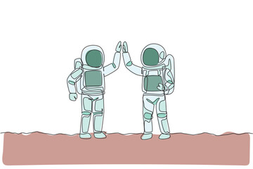 One continuous line drawing of two young happy astronauts giving high five gesture to celebrate teamwork in moon surface. Spaceman concept. Dynamic single line draw design vector graphic illustration