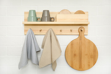 Obraz na płótnie Canvas Different towels and wooden board hanging on rack in kitchen