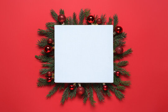 Blank canvas and Christmas decor on red background, flat lay. Space for design