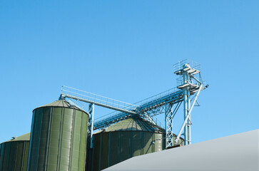 Obraz premium Modern granaries for storing cereal grains against blue sky, low angle view