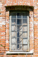 Fototapeta na wymiar Broken window, of an old dilapidated deserted brick building