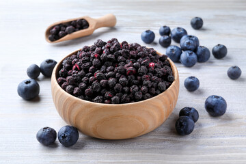 Freeze dried and fresh blueberries on white wooden table